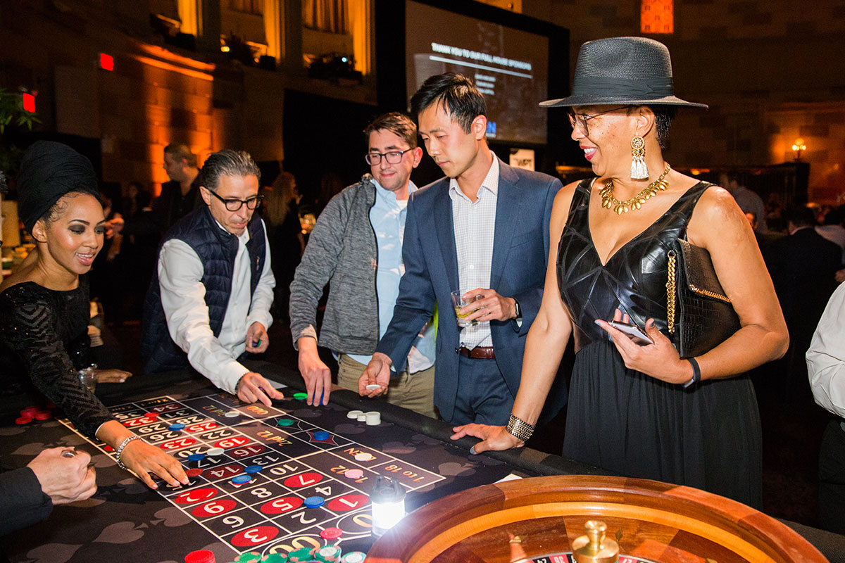 Woman in a fedora with three men playing roulette